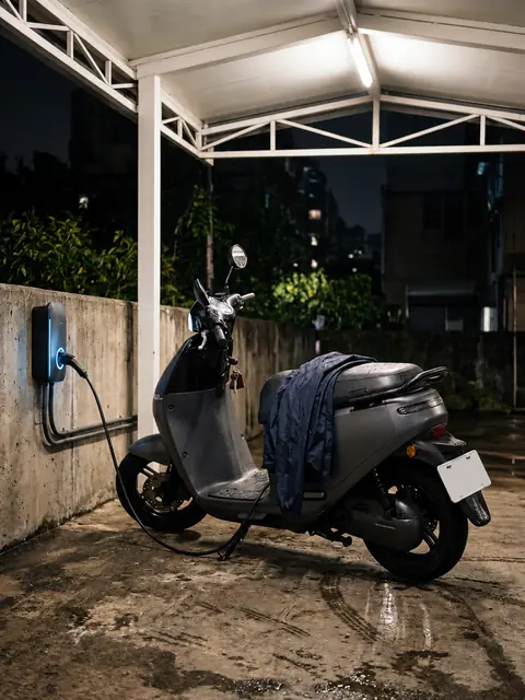 An electric scooter charging under a shed
